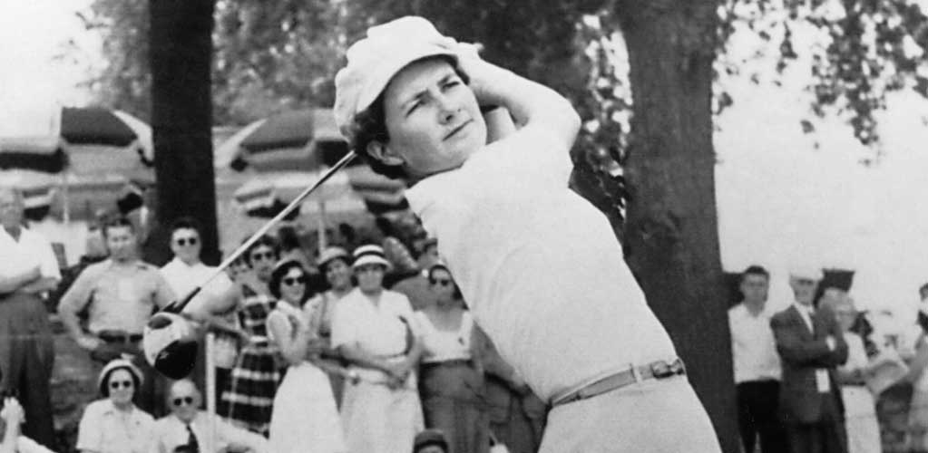 Louise Suggs, LPGA co-founder and major champion, posed with golf clubs