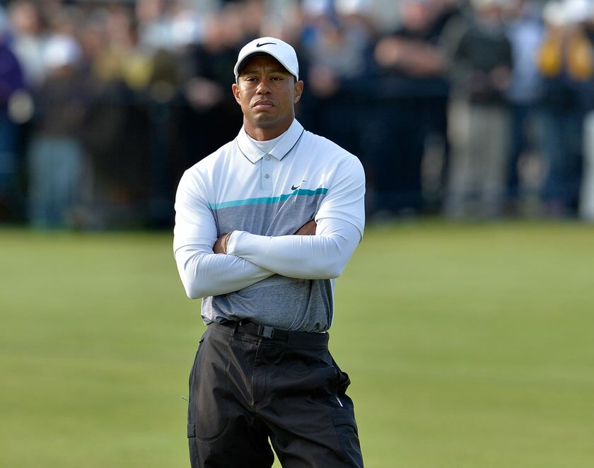 Golfer accepting a trophy at a regular tour event with sponsors and leaderboard visible