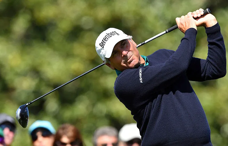 Golfer celebrating on a major championship green with flagstick and crowd