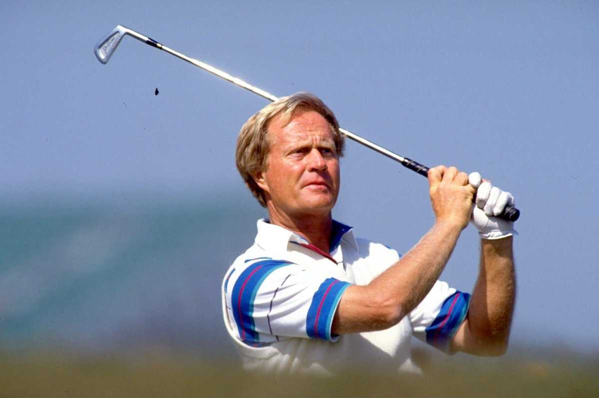 Jack Nicklaus leaning on his putter while holding the Wanamaker Trophy after a major championship victory